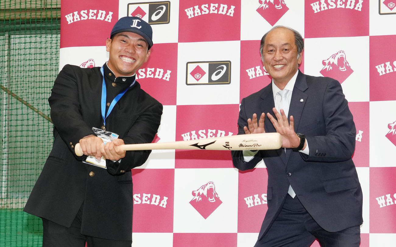 指名あいさつを受けた後、記念撮影で捕手役を務める西武渡辺久信GM（右）の横でポーズをとるドラフト1位の早大・蛭間（撮影・菅敏）