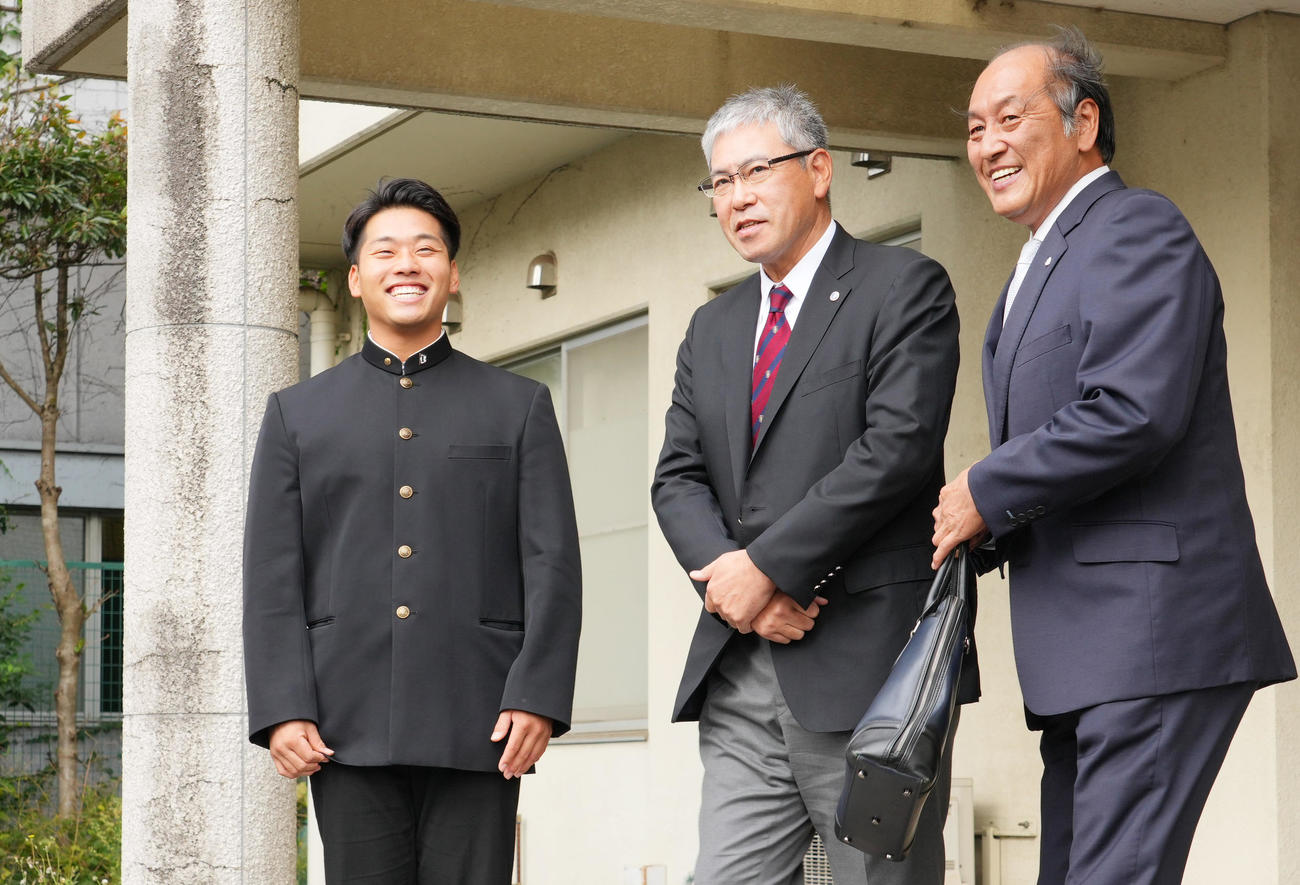 指名あいさつに訪れた西武の渡辺GМ（右）を寮の前で出迎えるドラフト1位の早大・蛭間。中央は小宮山監督（撮影・菅敏）