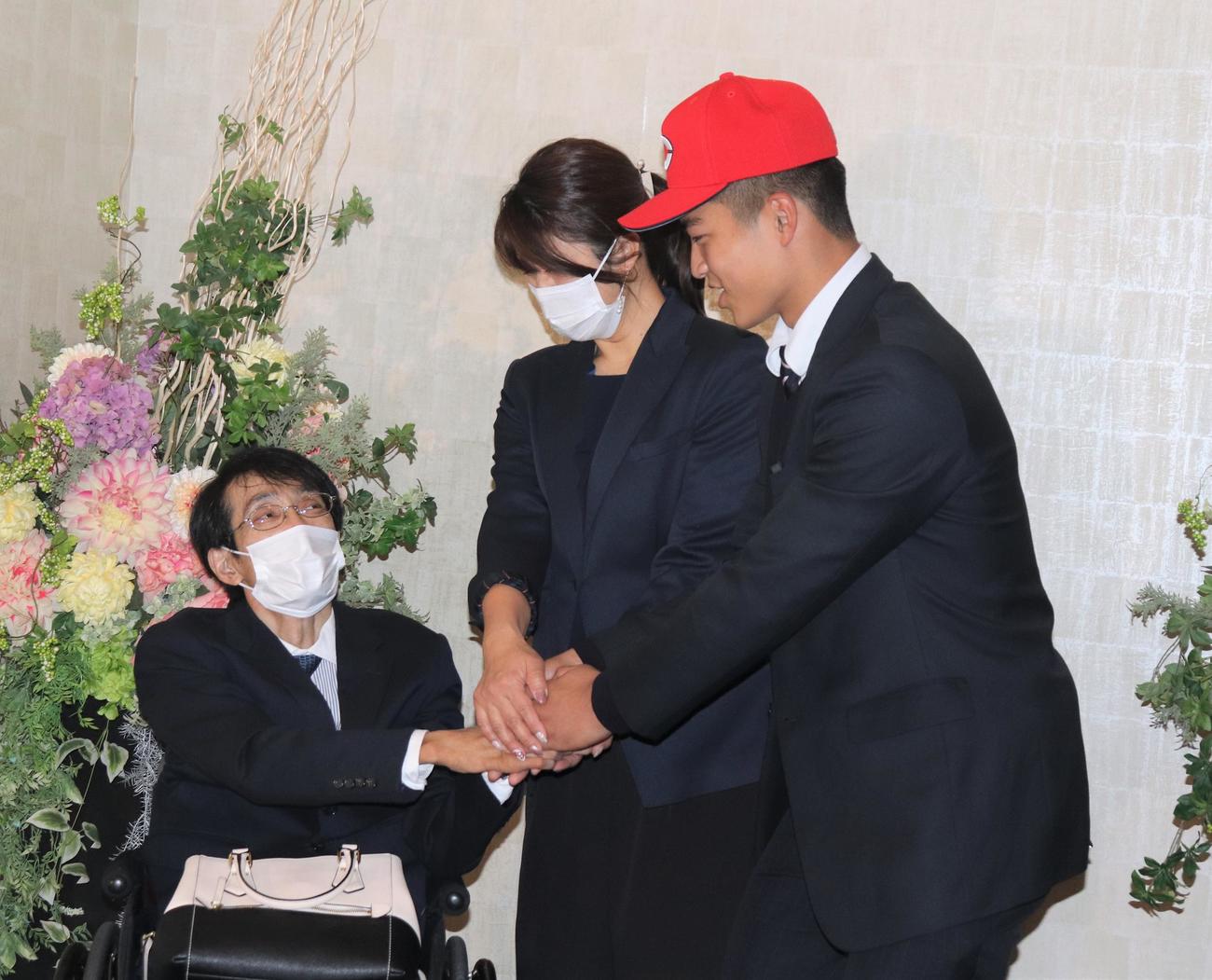 父・清司さん（左）から声をかけられる広島と仮契約した2位指名の利根商・内田（撮影・星夏穂）