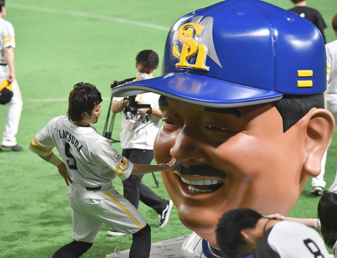 鷹の祭典2022仕様となった藤本監督の巨大な顔モニュメント「BIGFACE藤本」の鼻に手を突っ込む松田（撮影・岩下翔太）