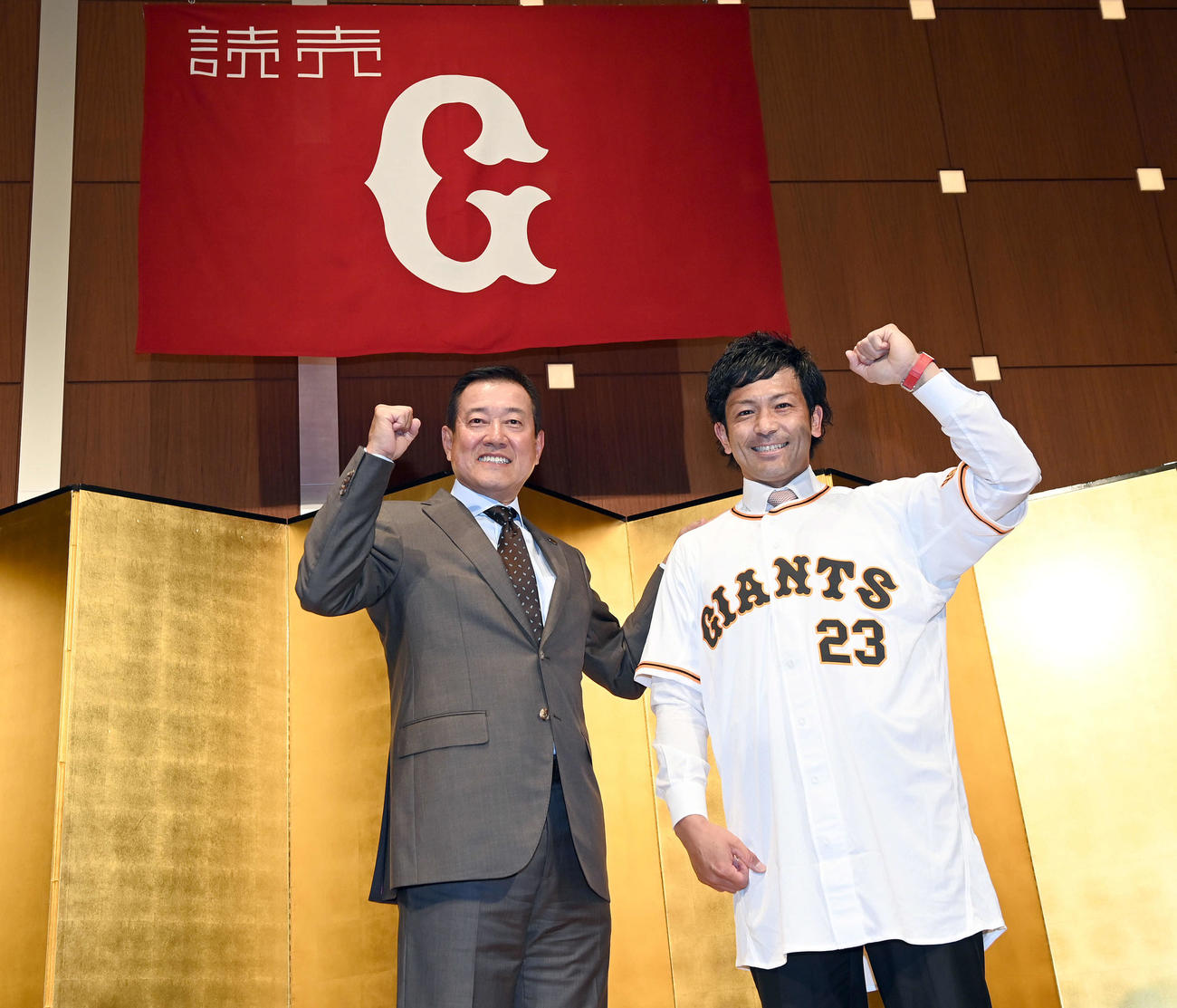 背番号「23」に袖を通し笑顔を見せる巨人松田。左は原監督（撮影・たえ見朱実）