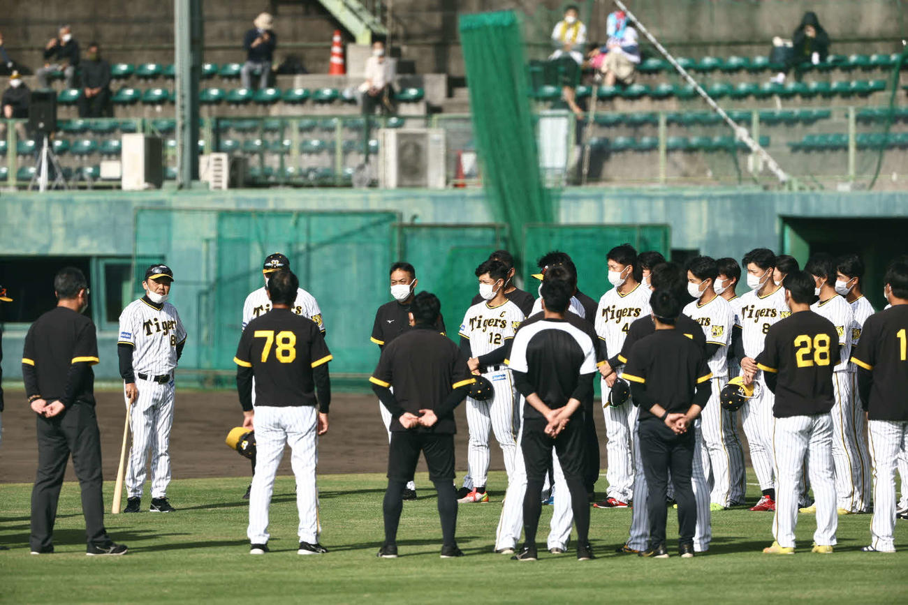岡田彰布監督（左から2人目）は練習前の円陣でナインに話をする（撮影・上田博志）