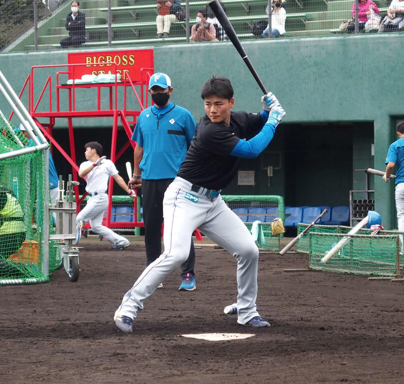 日本ハム稲葉ゼネラルマネジャー（後方）が見守る中、ロングティー打撃をする清宮（撮影・中島宙恵）