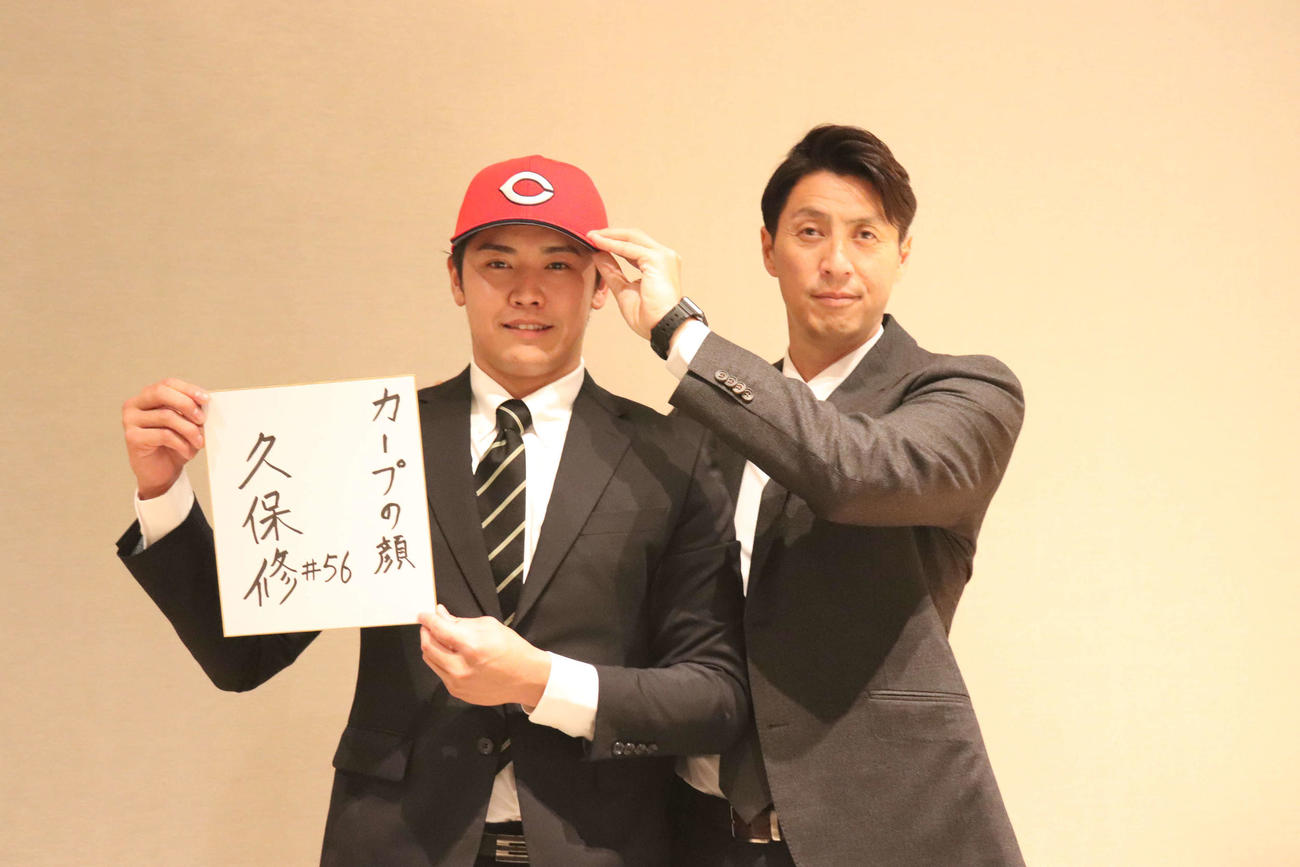 仮契約を終えた、広島ドラフト7位の大阪観光大・久保（左）と担当の鞘師スカウト