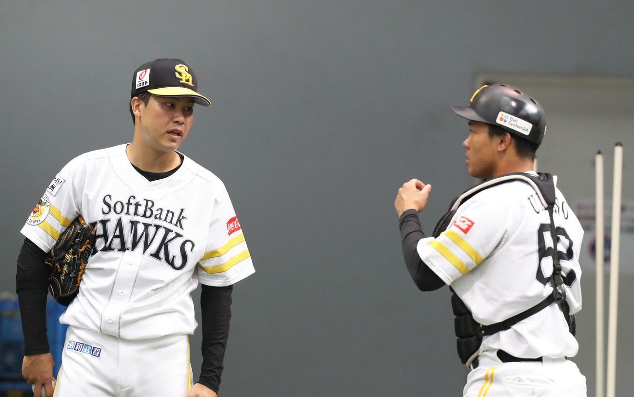 ブルペンでの投球練習後に、海野（右）と話し合う藤井（撮影・屋方直哉）