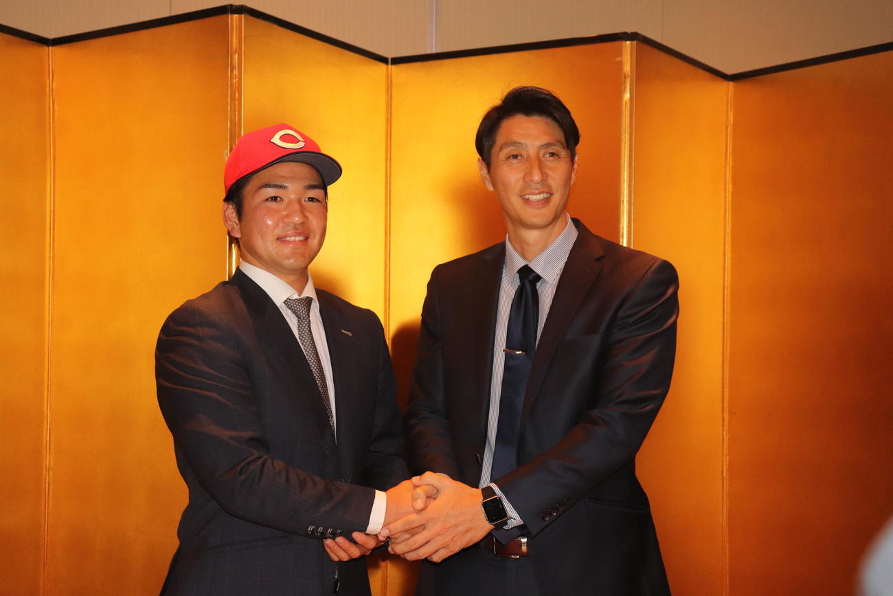 握手する2人。左から河野佳投手、広島・鞘師智也スカウト（撮影・竹本穂乃加）＝2022年11月16日、兵庫県神戸市内