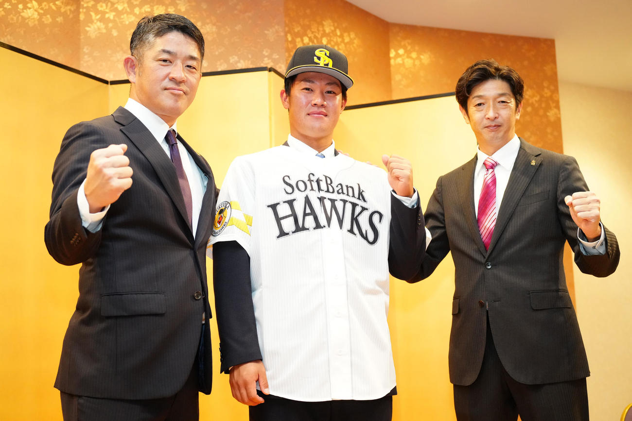 ソフトバンクと仮契約し、ガッツポーズを見せるドラフト6位の桐蔭横浜大・吉田（中央）。左は福山アマスカウトチーフ、右は松本アマスカウト（撮影・江口和貴）