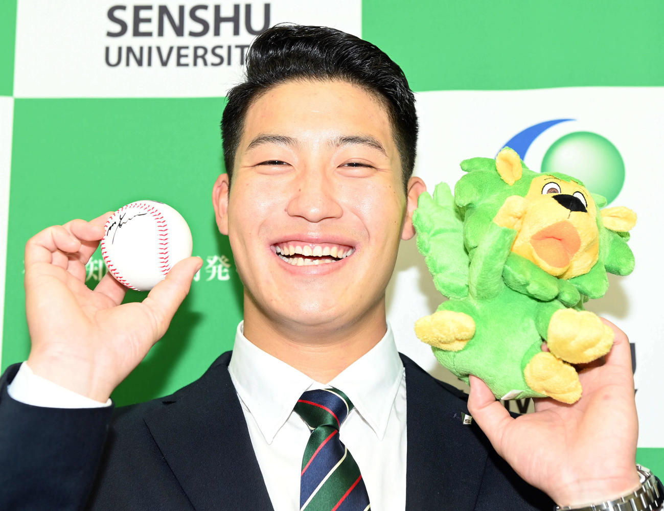 専大のキャラクター「センディ」とプレゼントされたロッテ吉井監督のサインボールを手に笑顔を見せる菊地（撮影・たえ見朱実）