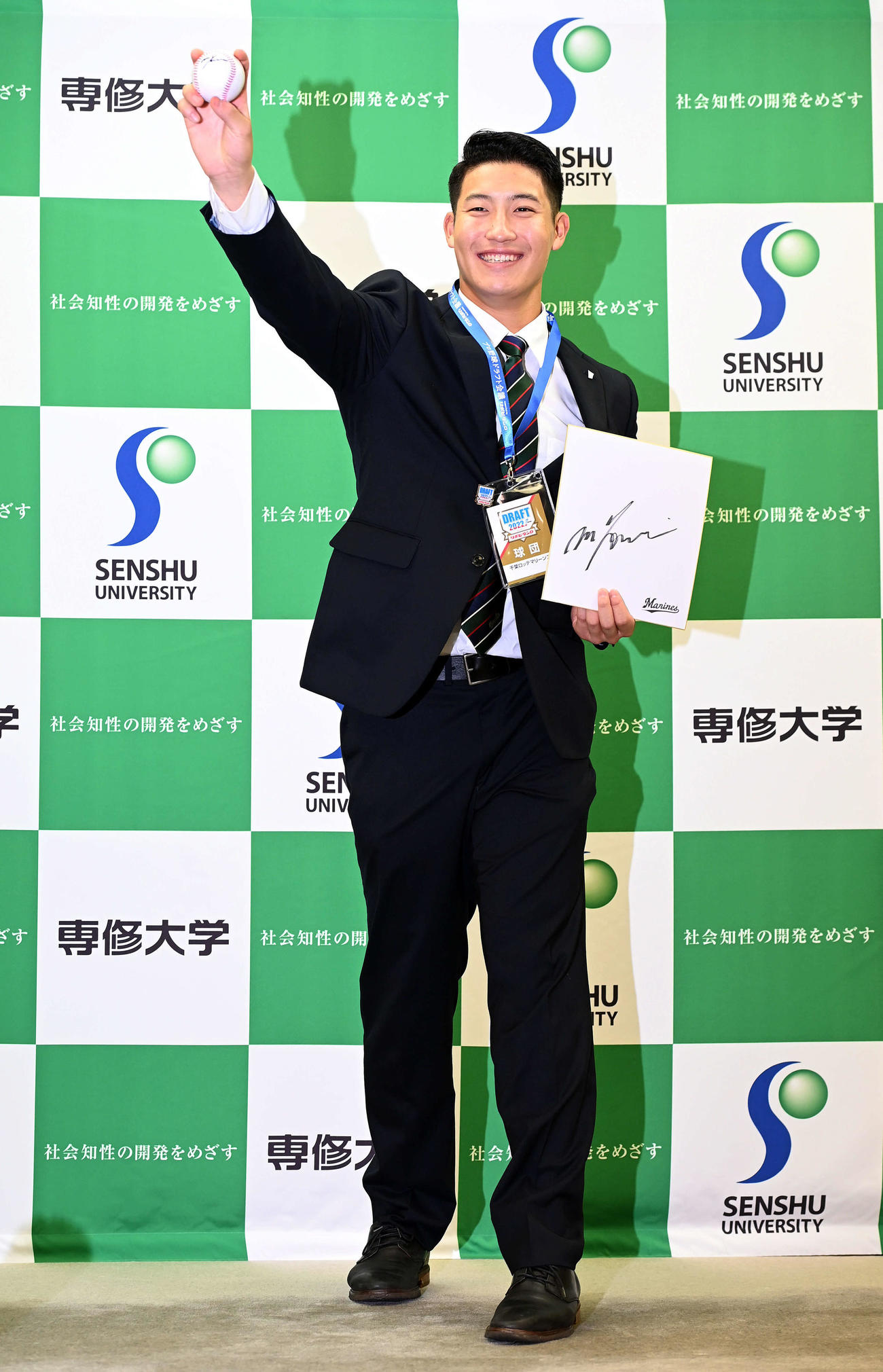 ドラフト指名あいさつを受けたロッテ1位の専大・菊地は、吉井監督から贈られたサインボールと色紙、IDを手に笑顔でポーズを決める（撮影・たえ見朱実）