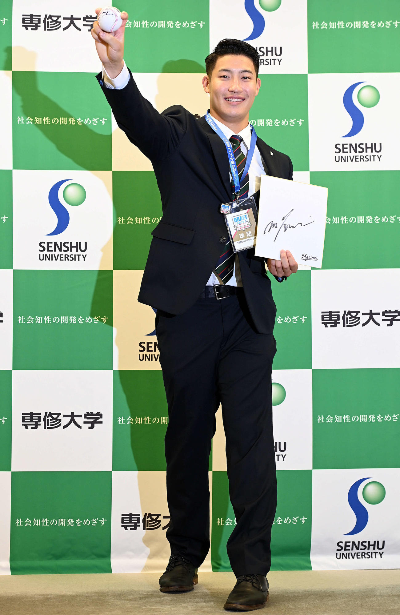 ドラフト指名あいさつを受けたロッテ1位の専大・菊地は、吉井監督から贈られたサインボールと色紙、IDを手に笑顔でポーズを決める（撮影・たえ見朱実）
