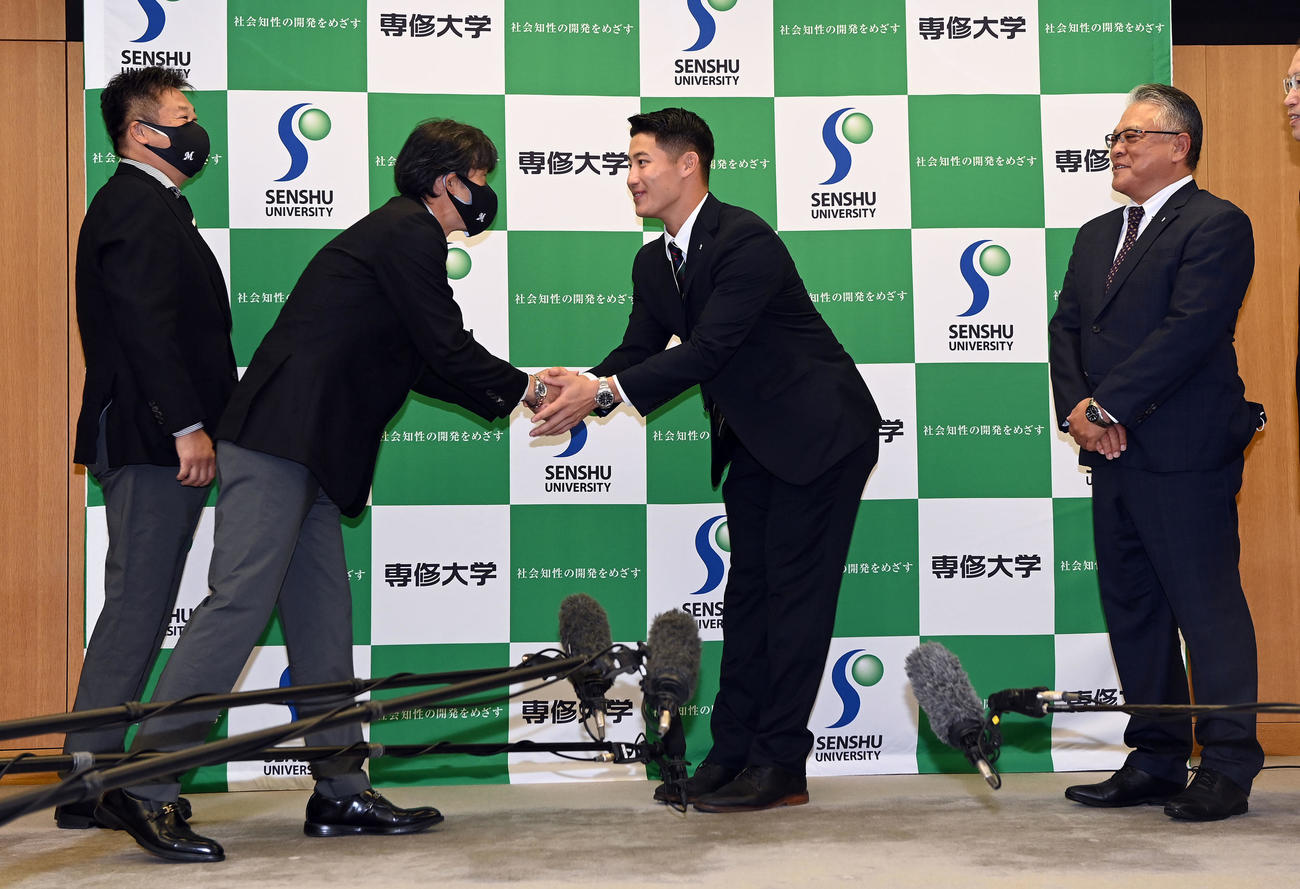 指名あいさつを受けロッテ榎スカウト部長（左端）、福沢スカウトを迎える専大・菊地（中央右）。右端は斎藤監督（撮影・たえ見朱実）