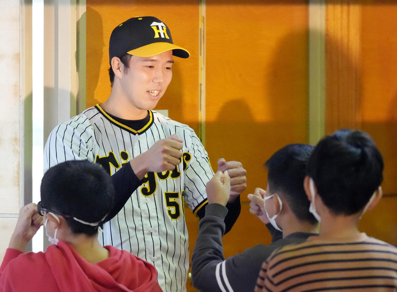 地元横浜市鶴見区にある上寺尾小学校を訪れ、別れ際に子どもたちとグータッチを交わす阪神青柳（撮影・狩俣裕三）