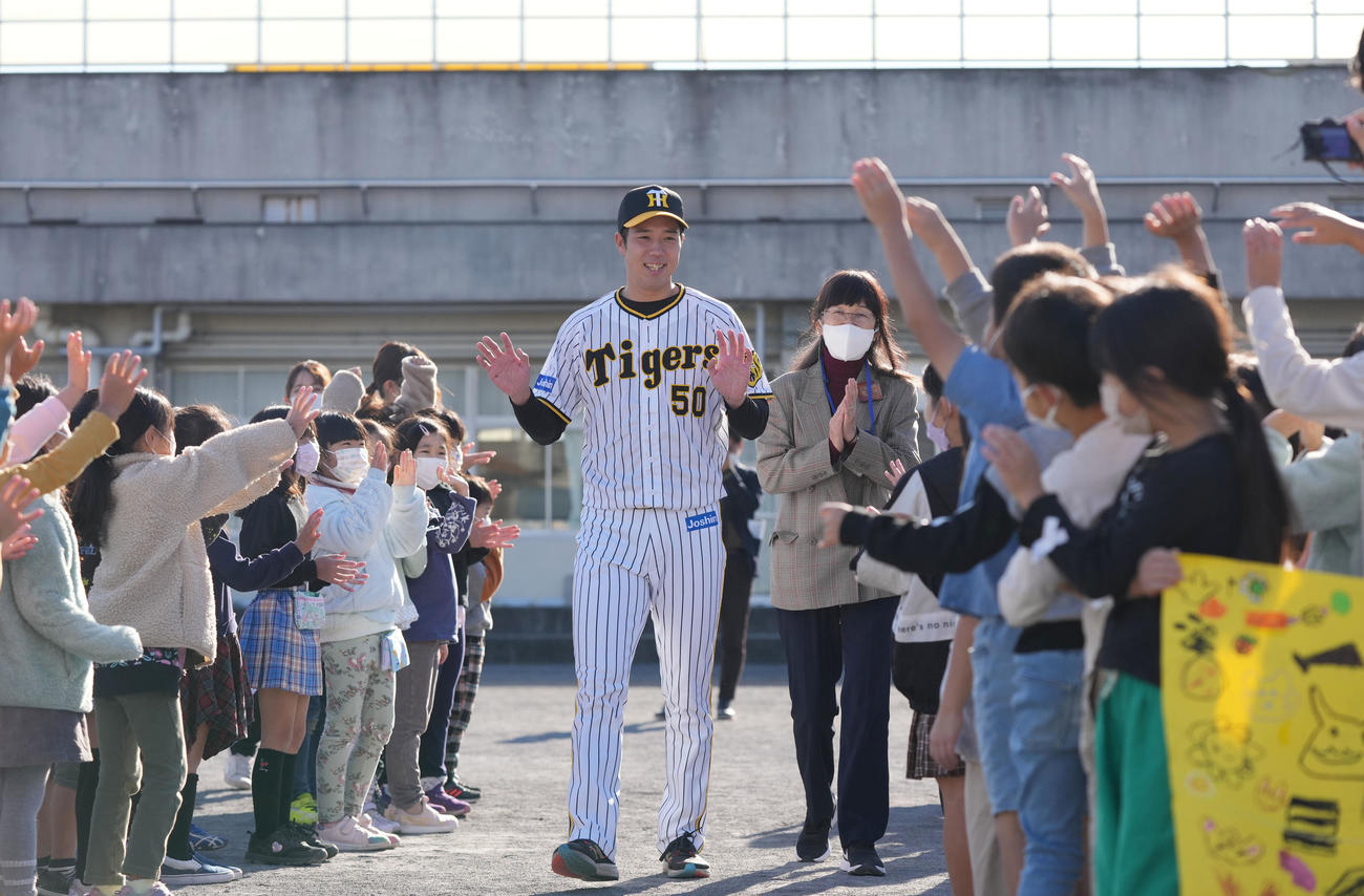 地元横浜市鶴見区にある岸谷小学校を訪れ、子どもたちの花道を笑顔で通り抜ける阪神青柳（撮影・狩俣裕三）