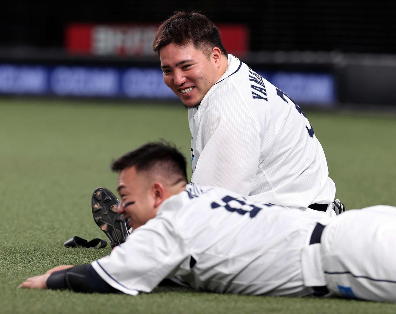 試合前、ストレッチしながら談笑する西武森（手前）と山川（2022年9月27日撮影）