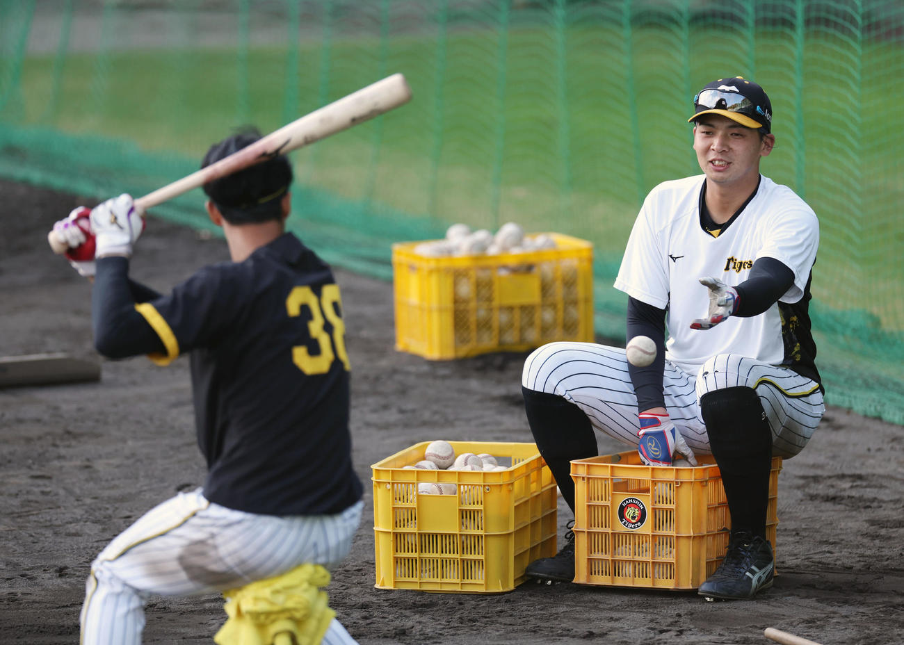 阪神小幡（左）のティー打撃でトスする井上（撮影・前田充）