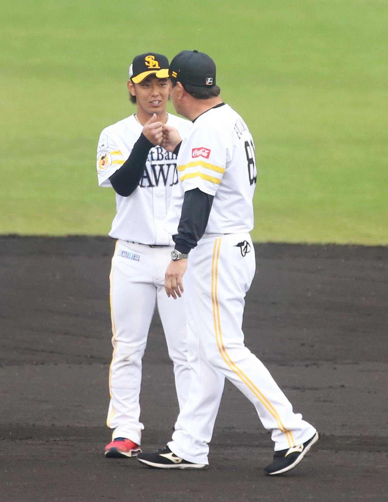 秋季キャンプを打ち上げ、藤本監督（右）とグータッチをする今宮（撮影・屋方直哉）