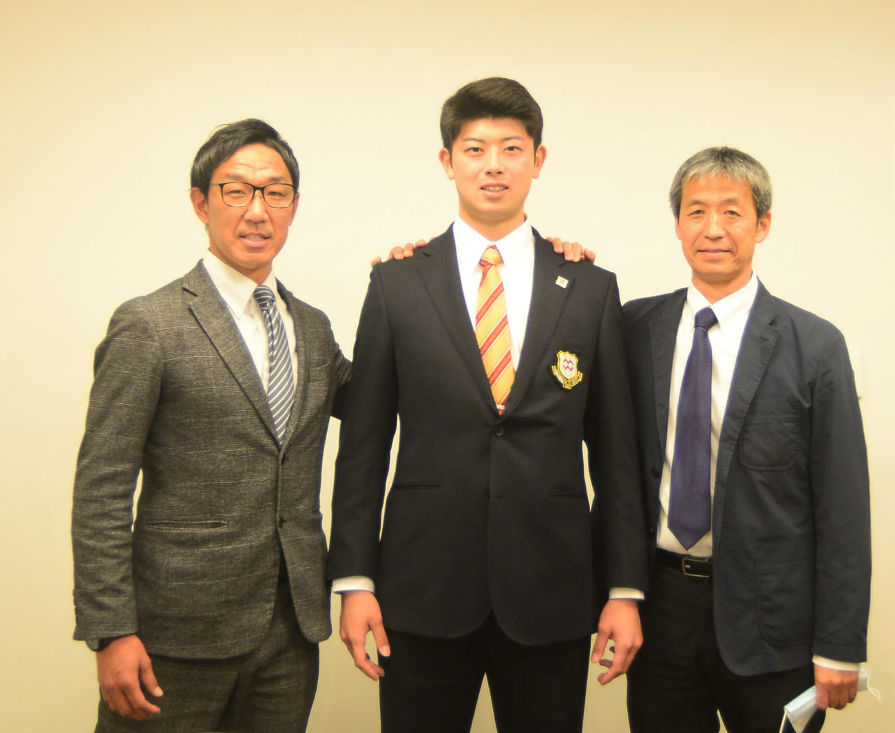 仮契約を終え、笑顔を見せる八戸学院大・松山（中央）と担当の中日八木スカウト（左）、八戸学院大・正村監督