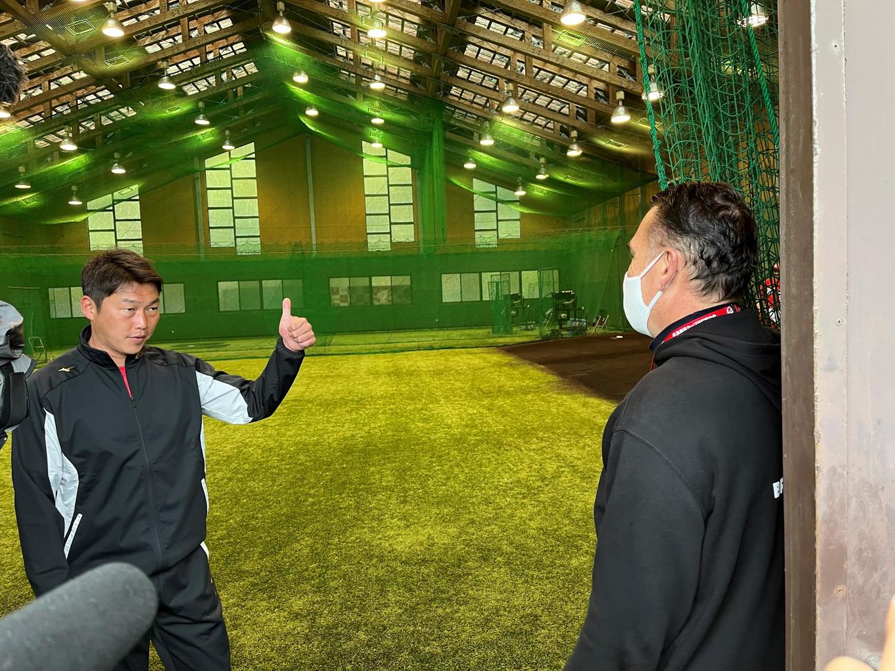 広島ケムナ誠投手の父ブルースさん（右）にサムズアップポーズでケムナをたたえる広島新井監督（撮影・前原淳）