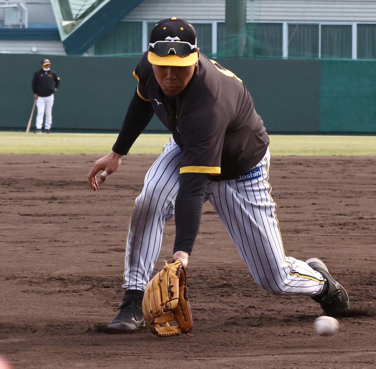 外野で見守る岡田監督（左）のチェックを受けながら三塁守備練習をする佐藤輝（撮影・上田博志）