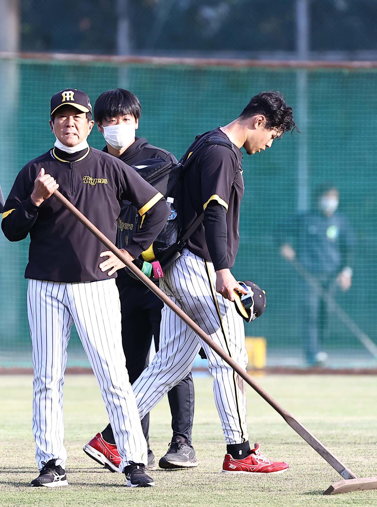 ノックを切り上げた佐藤輝（右）は平田ヘッドコーチに報告してからグラウンドを引き揚げる（撮影・上田博志）