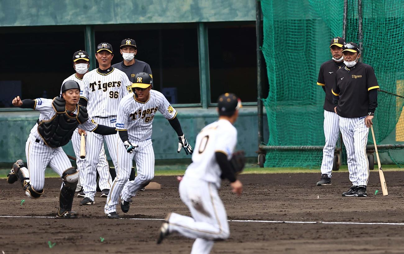岡田監督（右）は総合ノックの練習を見守る（撮影・上田博志）