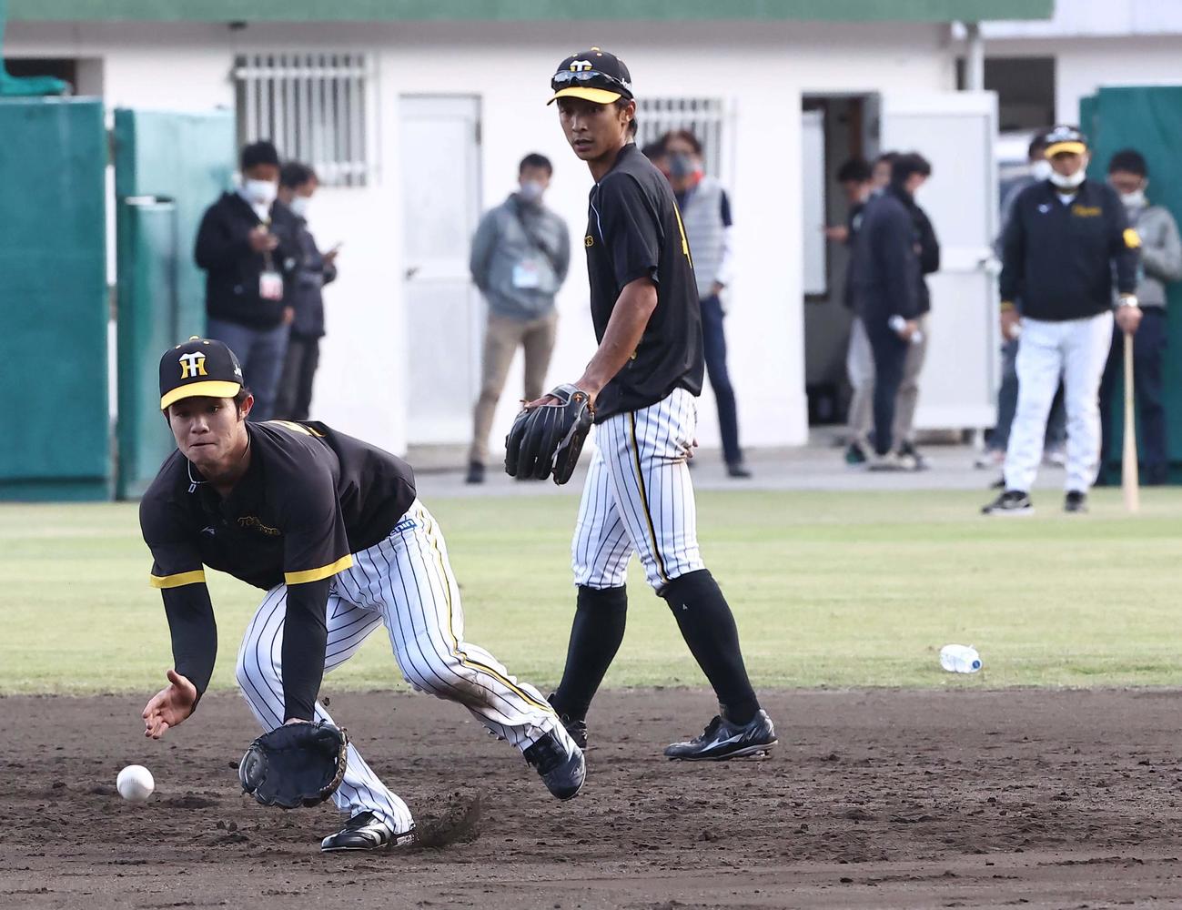 岡田監督（右）のチェックを受けながら二塁守備練習をする中野（左）と熊谷（撮影・上田博志）