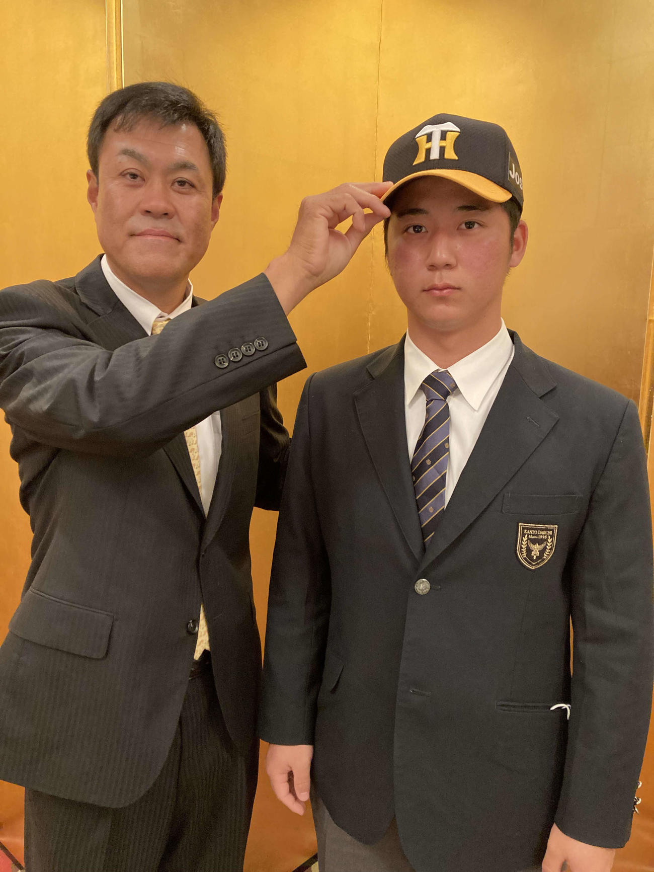 阪神と仮契約を結んだ関東第一・井坪。左は平塚スカウト（阪神タイガース提供）