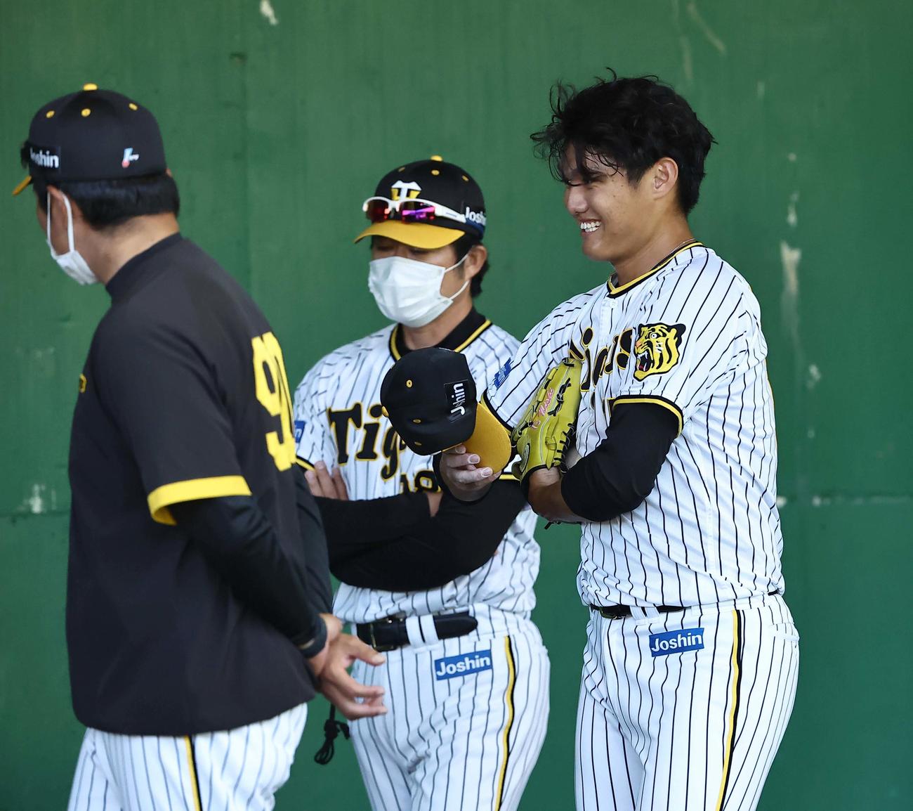 投球練習を終えた西純矢（右）は久保田コーチ（左）安藤コーチと笑顔で話す（撮影・上田博志）