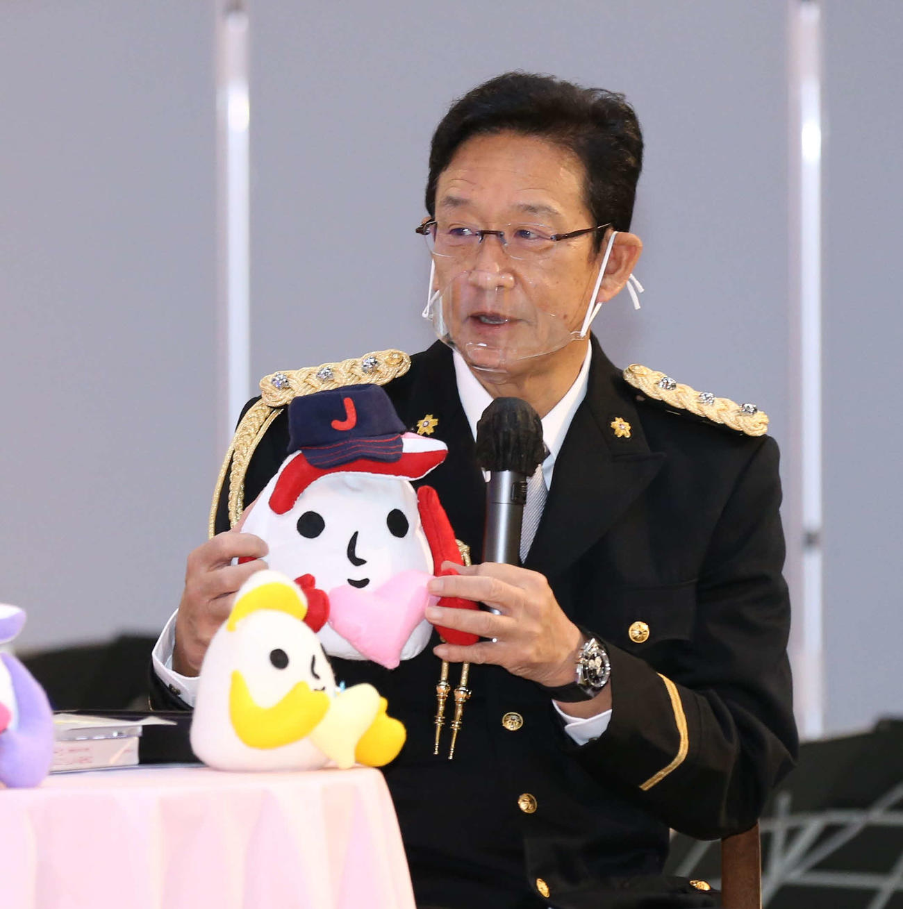 厚別警察署の一日署長を務めた日本ハムの栗山プロフェッサーは日本代表の帽子を被った縫いぐるみを手にトークショーをする（撮影・黒川智章）