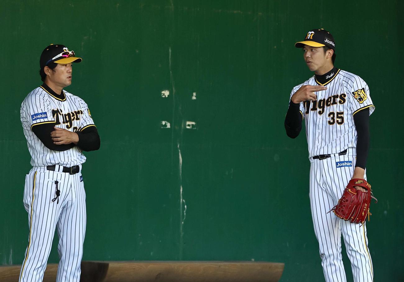 ブルペンで安藤コーチ（左）と話す才木（撮影・上田博志）