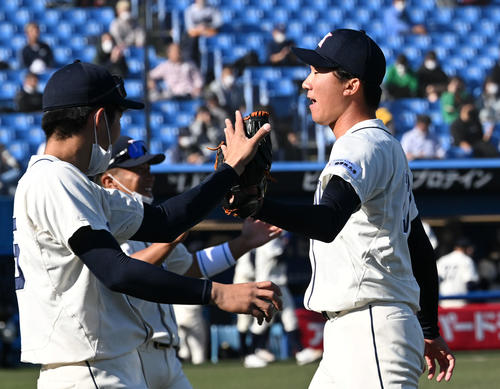 国学院大対大商大　1回裏を投げ終えた国学院大の田中千（右）はチームメートとタッチを交わす（撮影・滝沢徹郎）