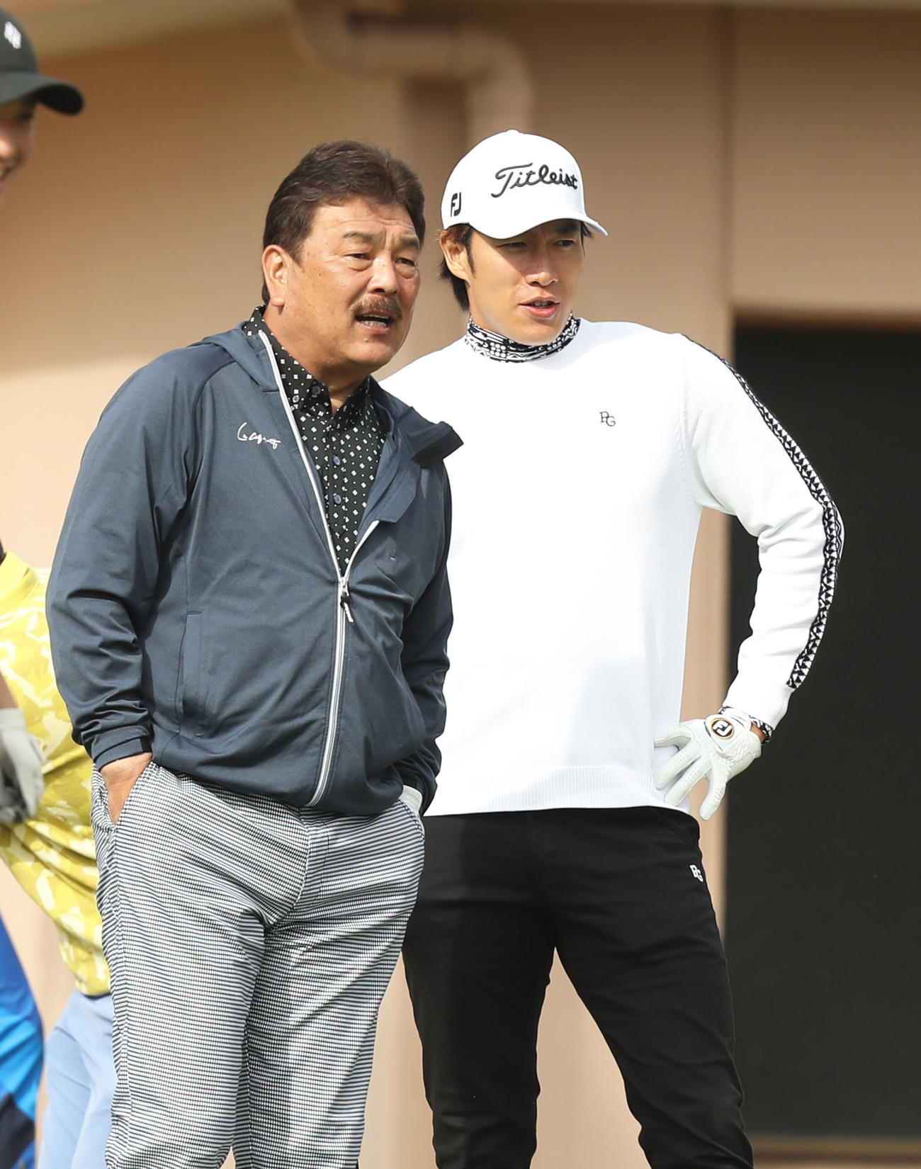 甲斐のティーショットのボールの行方を見つめる藤本監督（左）と柳田（撮影・屋方直哉）