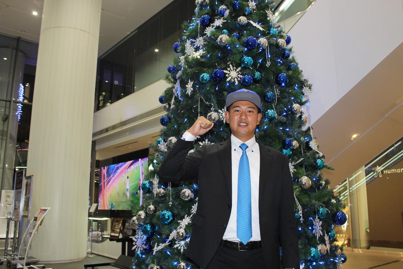 DeNAと仮契約を結び、クリスマスツリーの前でポーズを決めるドラフト2位のトヨタ自動車・吉野（撮影・久保賢吾）