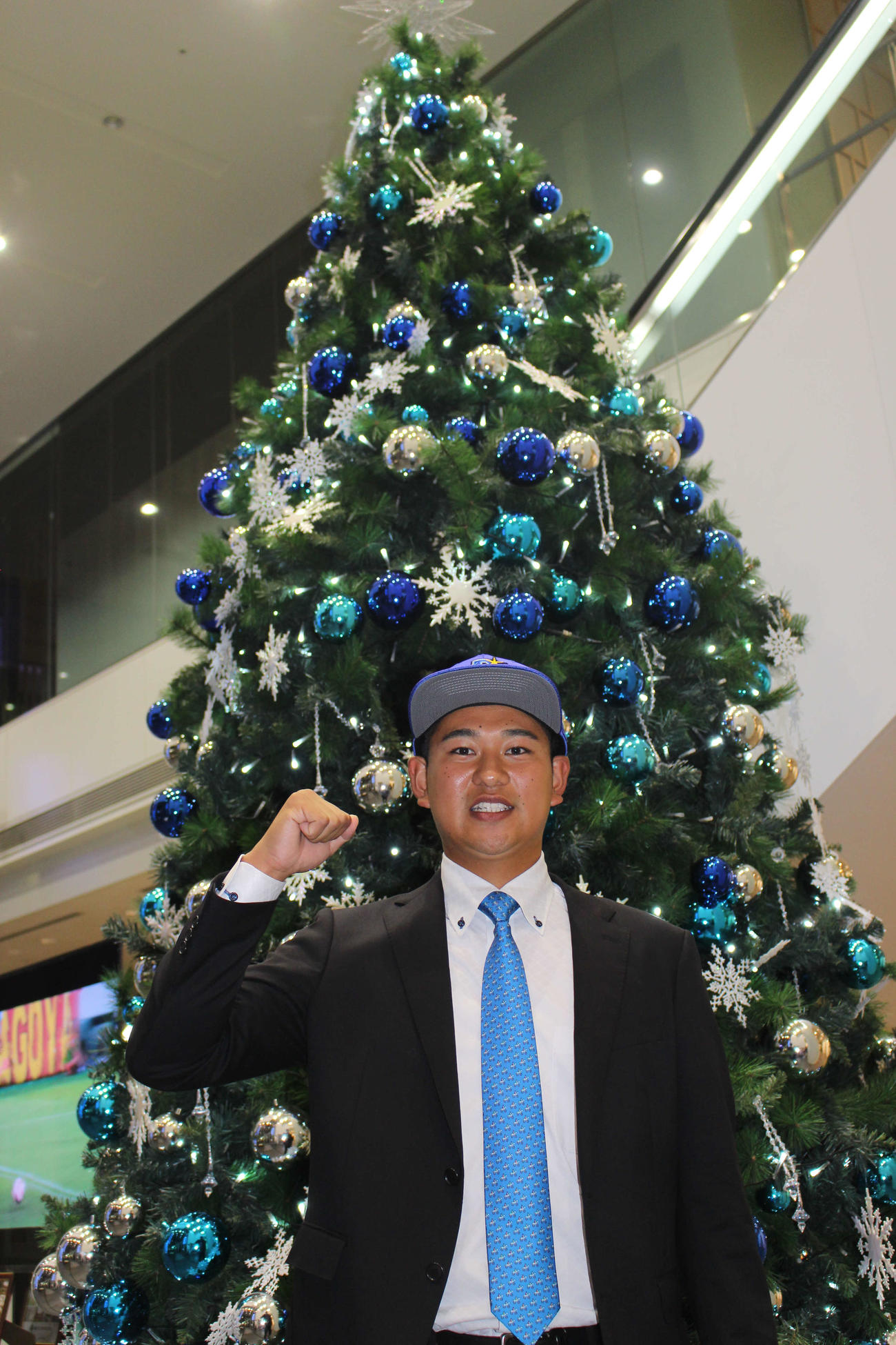 DeNAと仮契約を結び、クリスマスツリーの前でポーズを決めるドラフト2位のトヨタ自動車・吉野（撮影・久保賢吾）