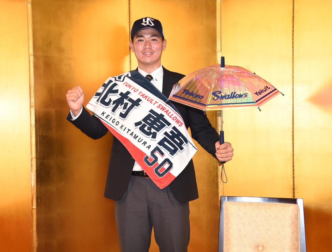 ヤクルトからドラフト5位指名を受けた中大・北村は仮契約を終え、オリジナルタオルと傘をガッツポーズ（撮影・鈴木正章）