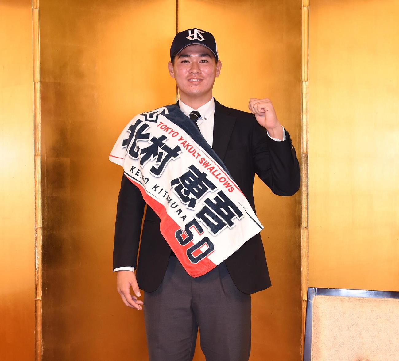 ヤクルトからドラフト5位指名を受けた中大・北村は仮契約を終え、オリジナルタオルを肩にガッツポーズ（撮影・鈴木正章）