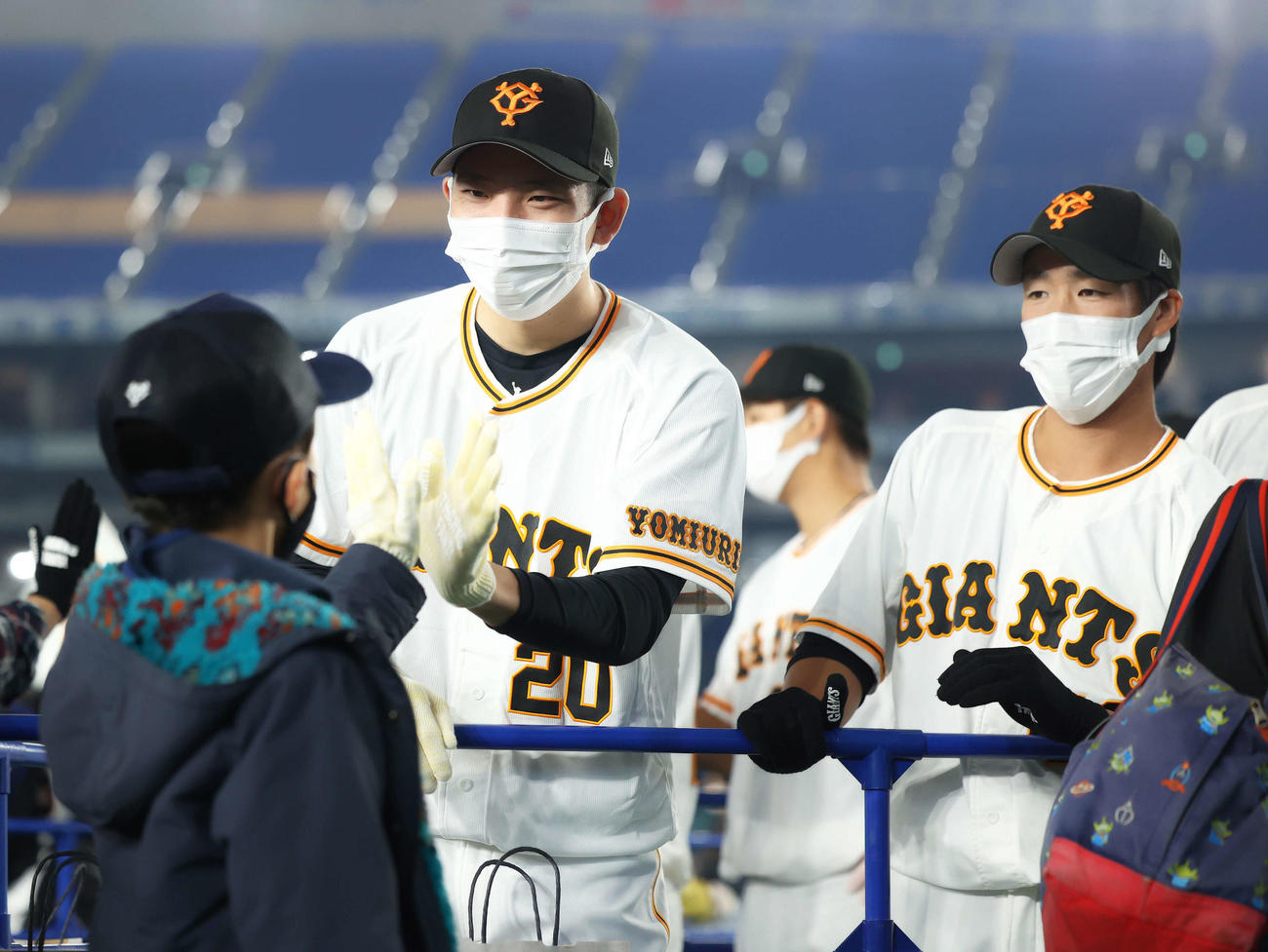 巨人ファン感謝デー　ファンとハイタッチする巨人戸郷（左）と重信（撮影・河田真司）