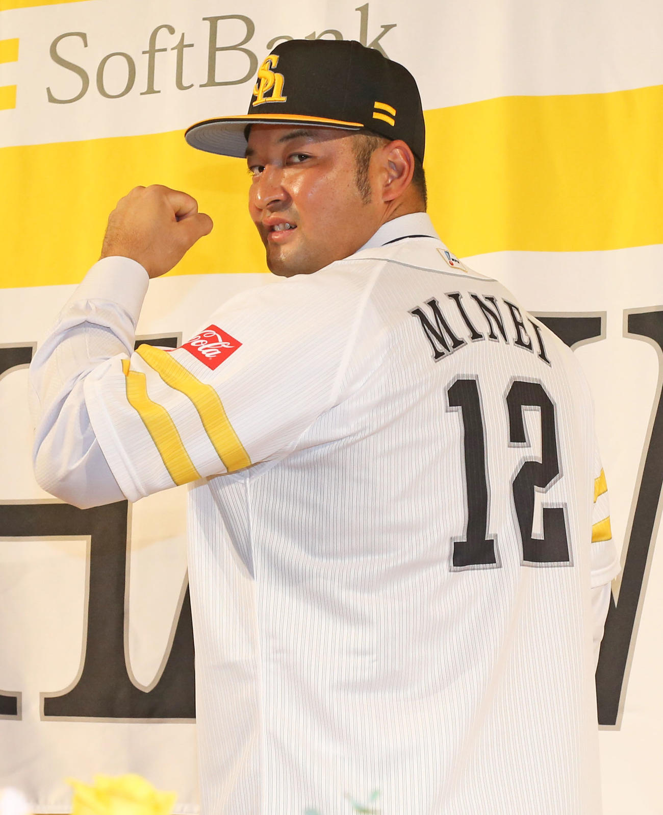 入団会見で背番号12番のユニホームを披露する嶺井（撮影・屋方直哉）