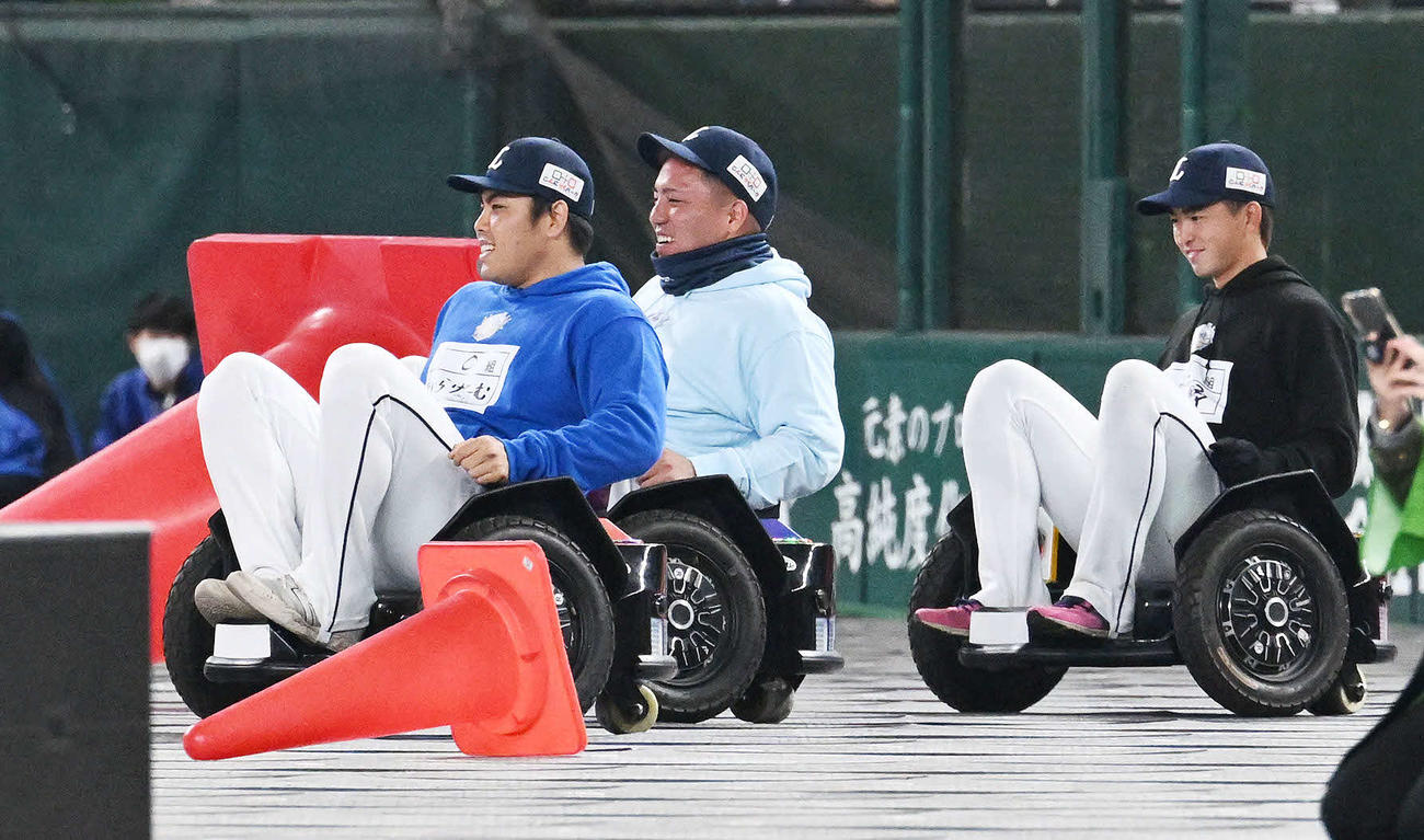タイヤの付いた乗り物で競争する西武山川（中央）と平良（左）と川野（撮影・滝沢徹郎）