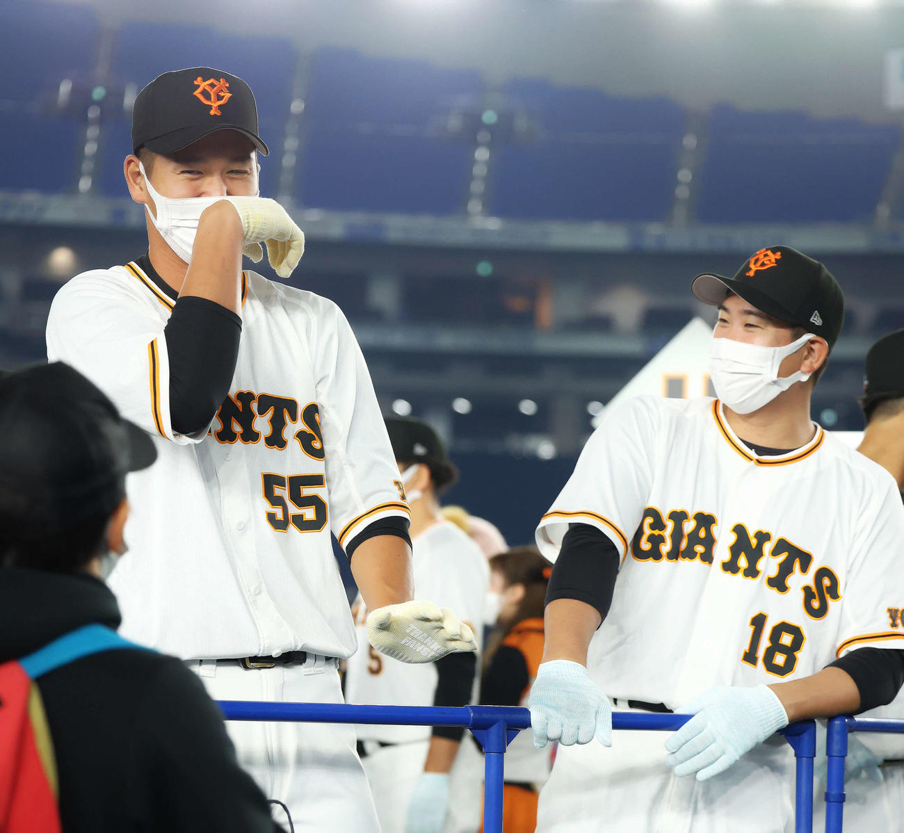 ファンとハイタッチする巨人秋広（左）と菅野（撮影・河田真司）