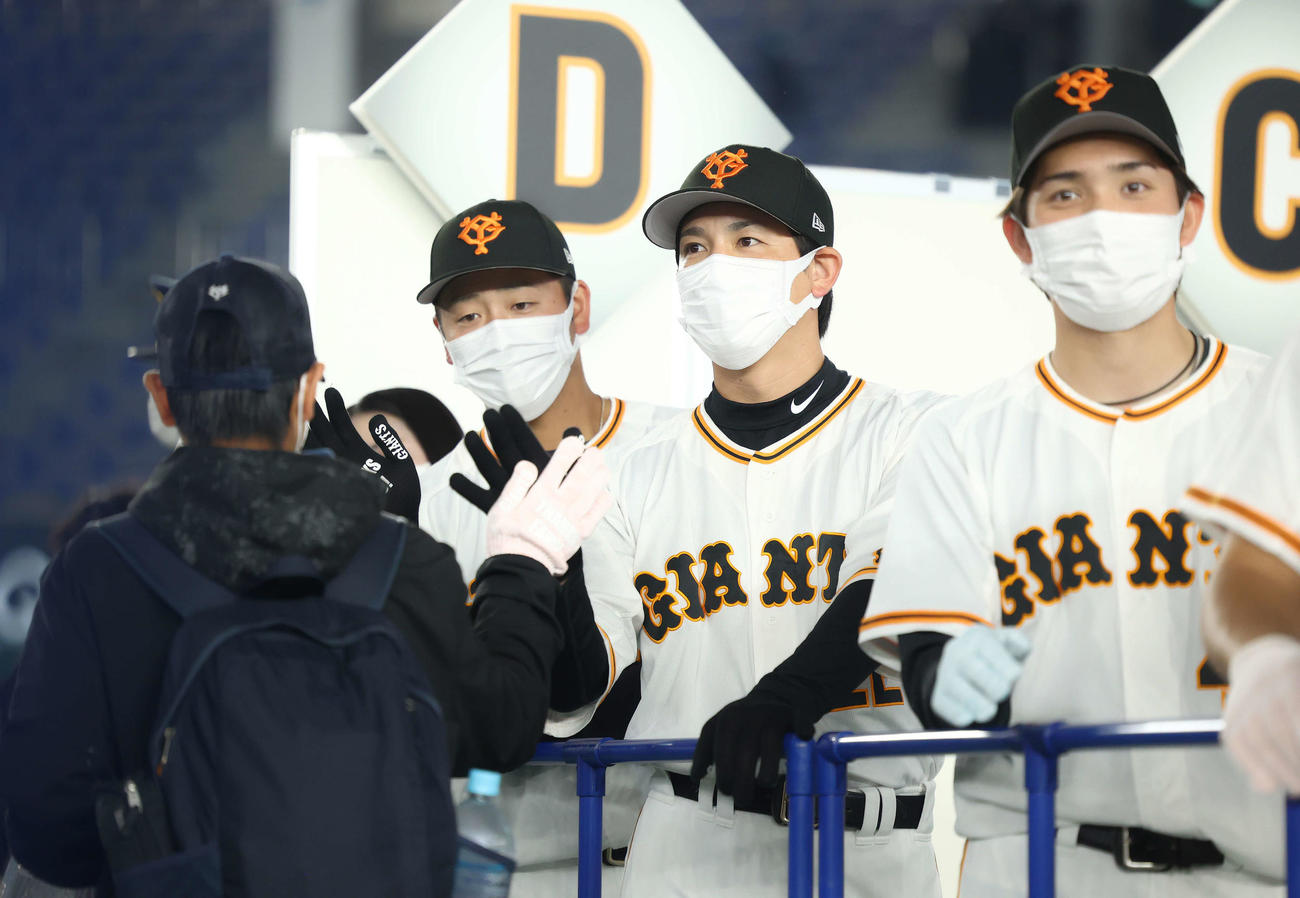 巨人ファン感謝デー　ファンとハイタッチする巨人の、左から岸田、小林、高橋（撮影・河田真司）