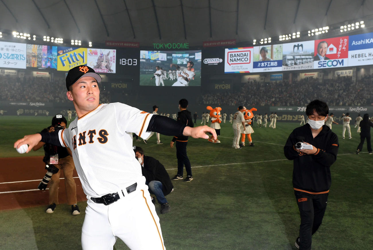 サインボールを投げ入れる新入団選手の巨人浅野（撮影・たえ見朱実）