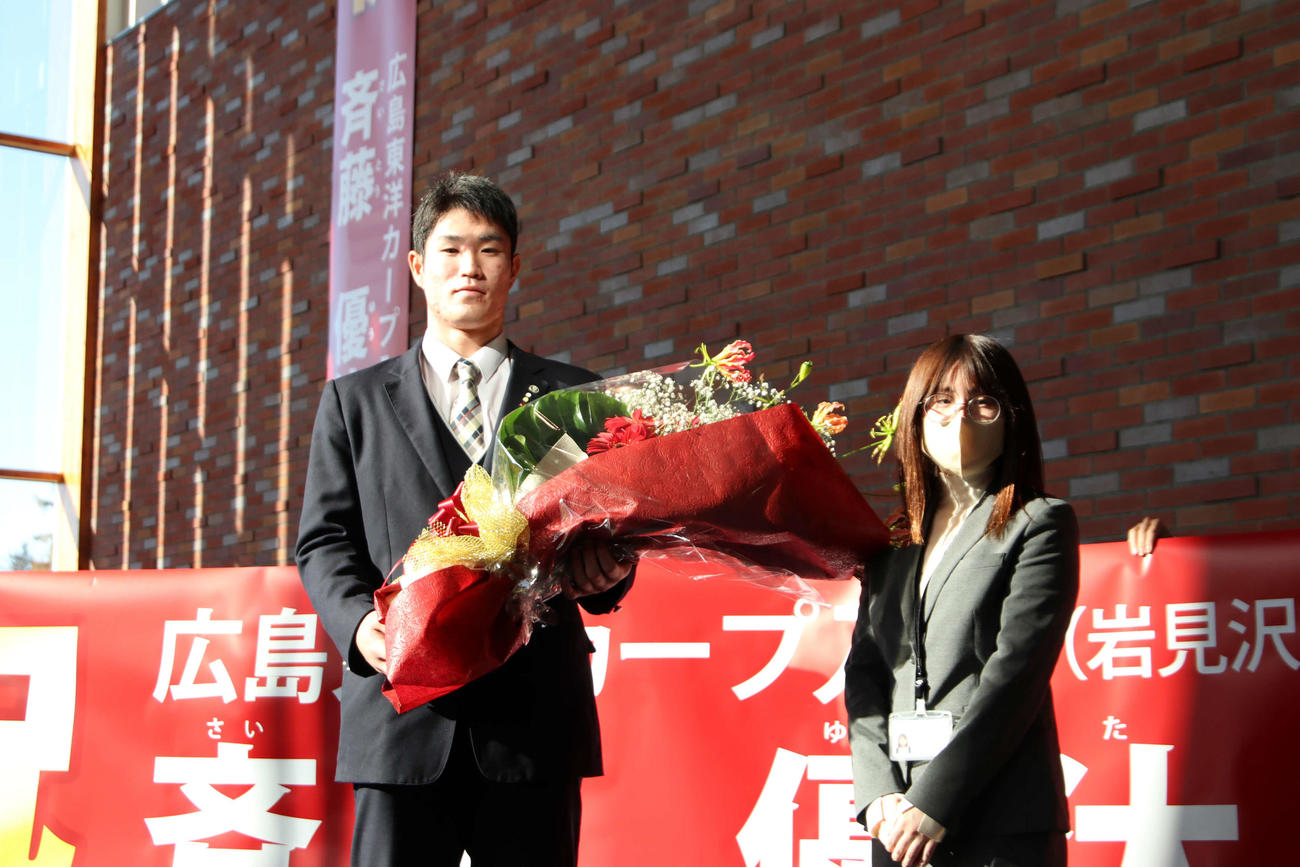 北海道・岩見沢市役所を表敬訪問し、花束を受け取る広島ドラフト1位の苫小牧中央・斉藤（左）（撮影・山崎純一）