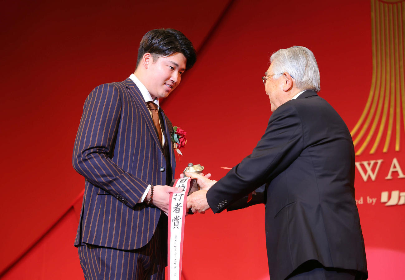 「NPB AWARDS 2022」のセ・リーグ首位打者賞、最多本塁者打賞、最多打点者賞、最高出塁率者賞の4冠に輝いたヤクルト村上（左）は斉藤コミッショナーから笑顔でトロフィーを受け取る（代表撮影）