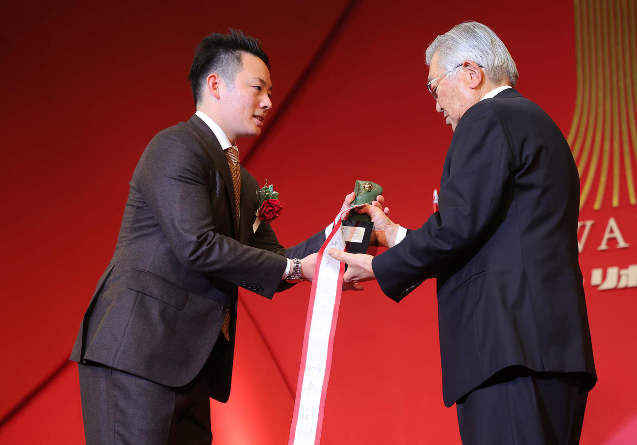 「NPB AWARDS 2022」でパ・リーグ最多セーブ投手賞に輝いた楽天松井裕（左）はNPB斉藤コミッショナーから笑顔でトロフィーを受け取る（代表撮影）