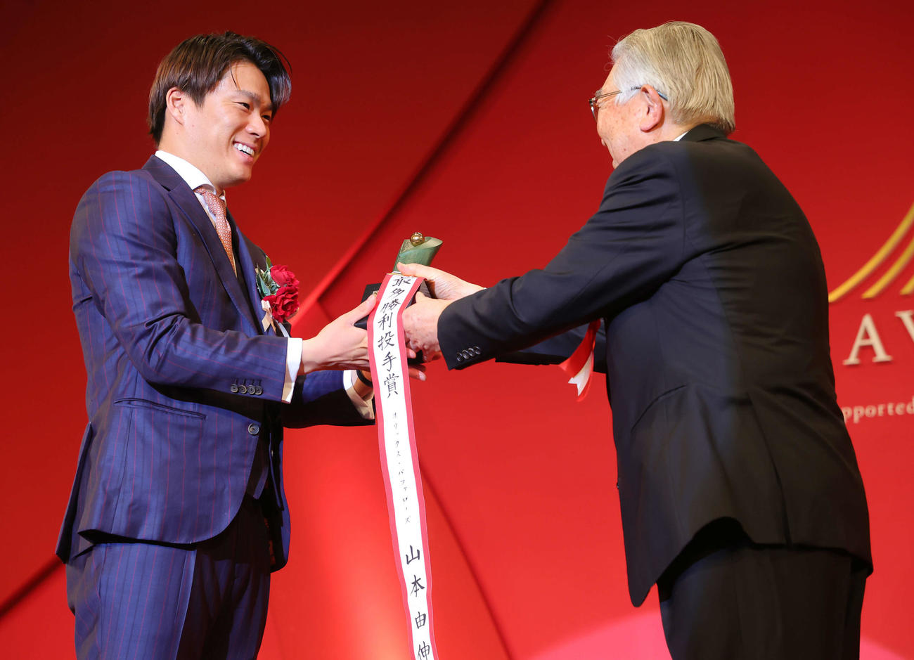 「NPB AWARDS 2022」でパ・リーグ最優秀防御率投手賞、勝率第1位投手賞、最多勝利投手賞、最多三振奪取投手賞の投手4冠に輝いたオリックス山本（左）はNPB斉藤コミッショナーから笑顔でトロフィーを受け取る（代表撮影）