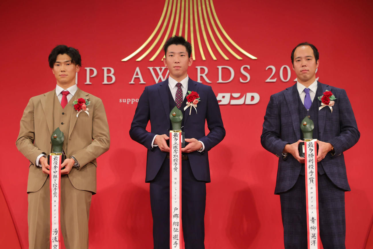 「NPB AWARDS 2022」のセ・リーグ投手部門でタイトルを獲得した阪神湯浅（左）、巨人戸郷（中央）、阪神青柳はトロフィーを手に記念撮影（代表撮影）
