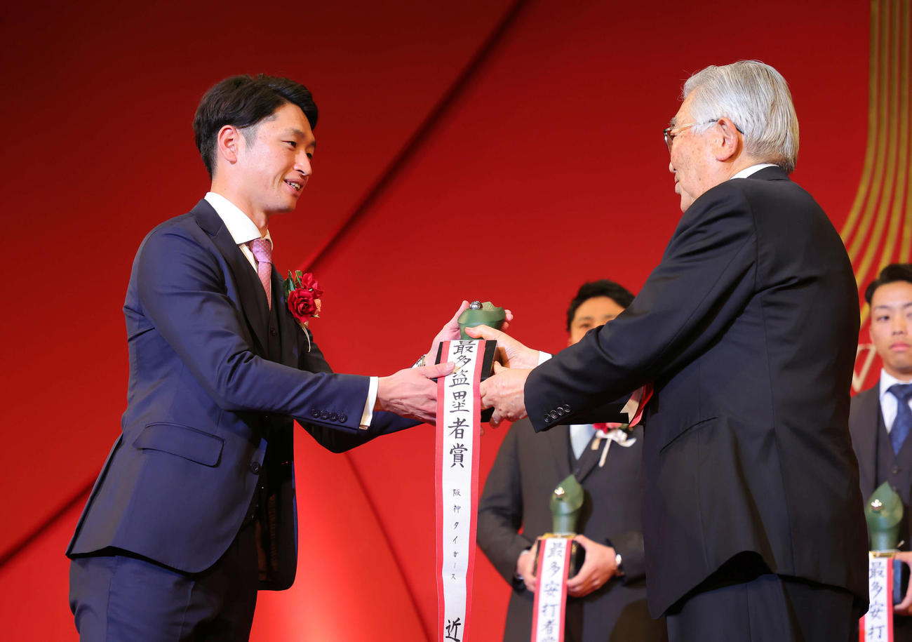 「NPB AWARDS 2022」のセ・リーグ最多盗塁者賞に輝いた阪神近本（左）は斉藤コミッショナーから笑顔でトロフィーを受け取る（代表撮影）