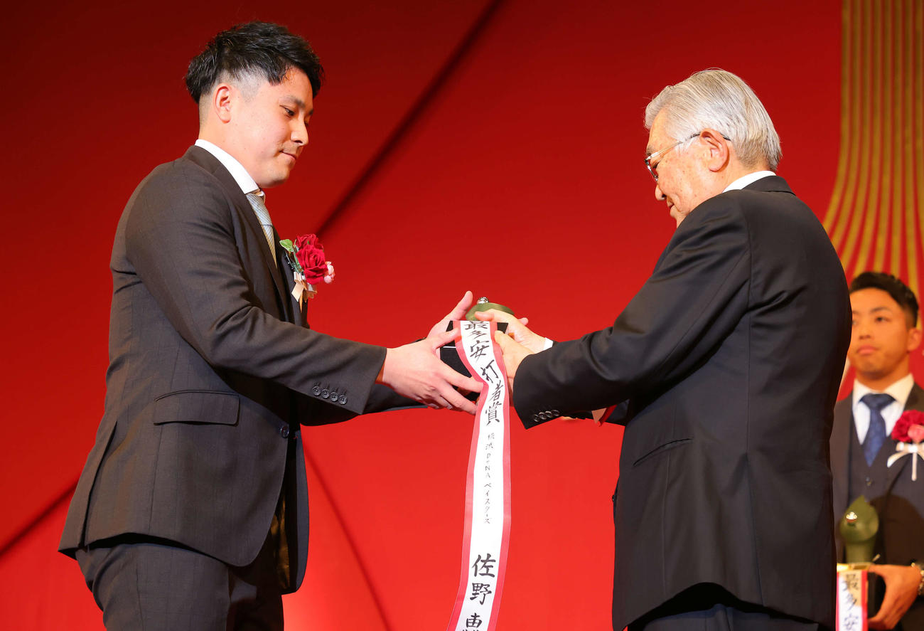 「NPB AWARDS 2022」のセ・リーグ最多安打者賞に輝いたDeNA佐野（左）は斉藤コミッショナーから笑顔でトロフィーを受け取る（代表撮影）