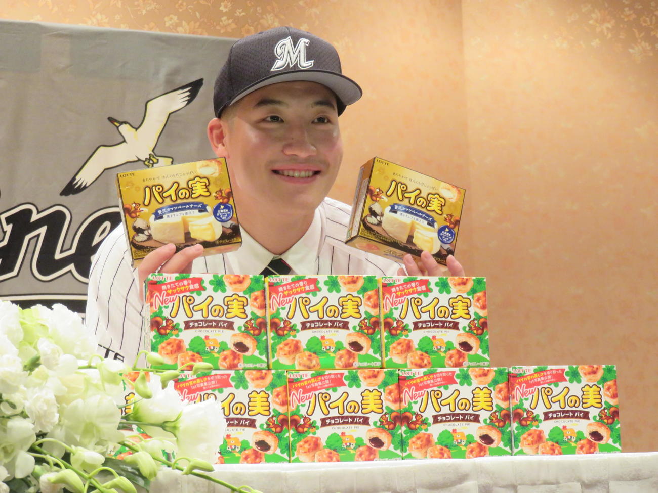 ロッテと契約を結んだドラフト1位の専大・菊地吏玖投手は好物のパイの実を手に笑顔